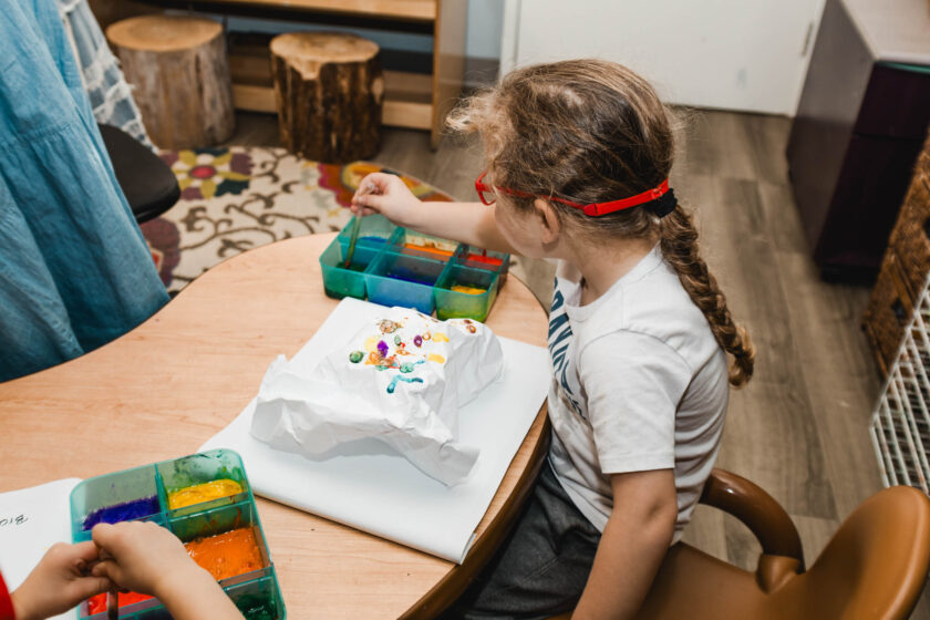A little girl crafting at a table.