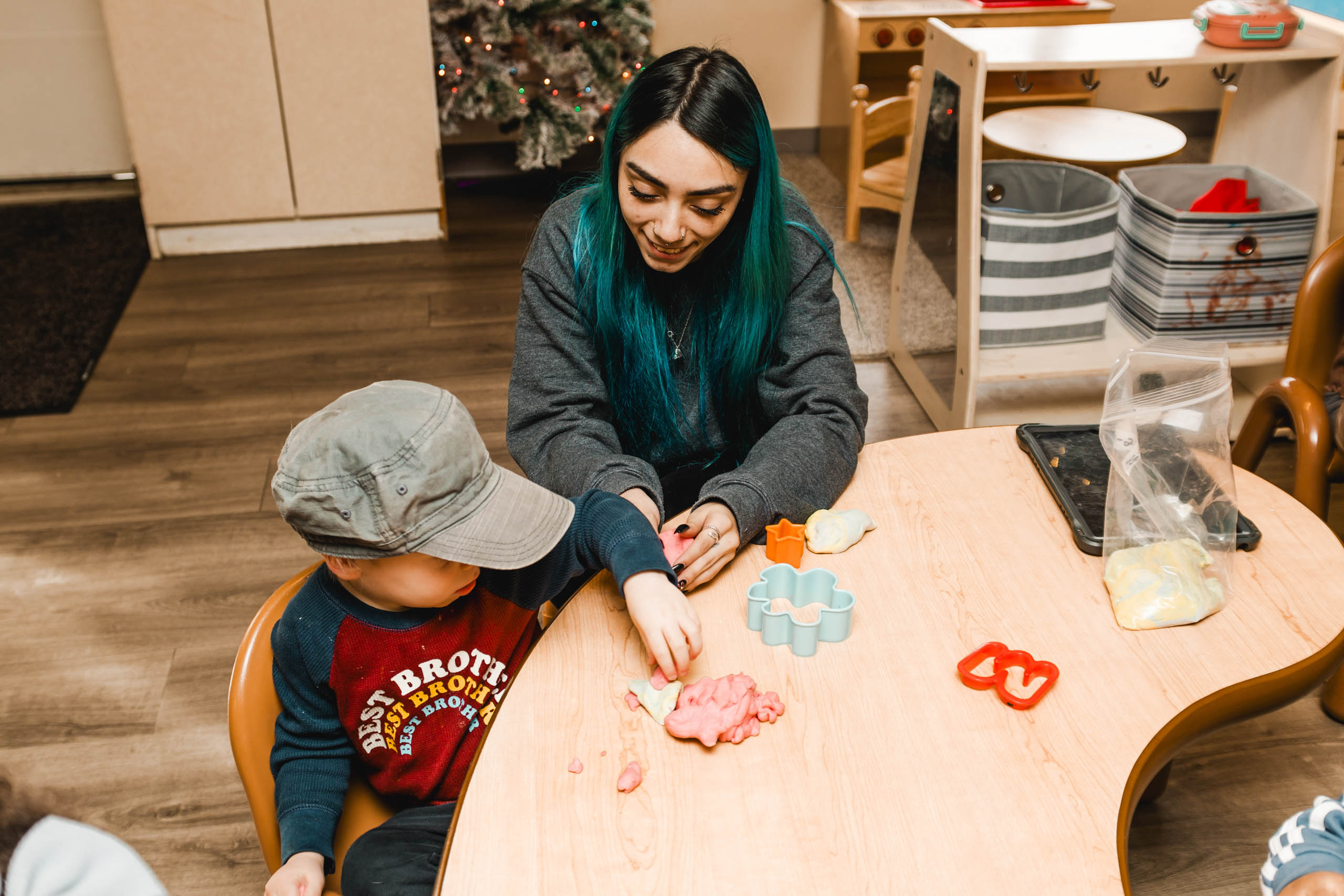 A teacher and little boy interacting at a table.
