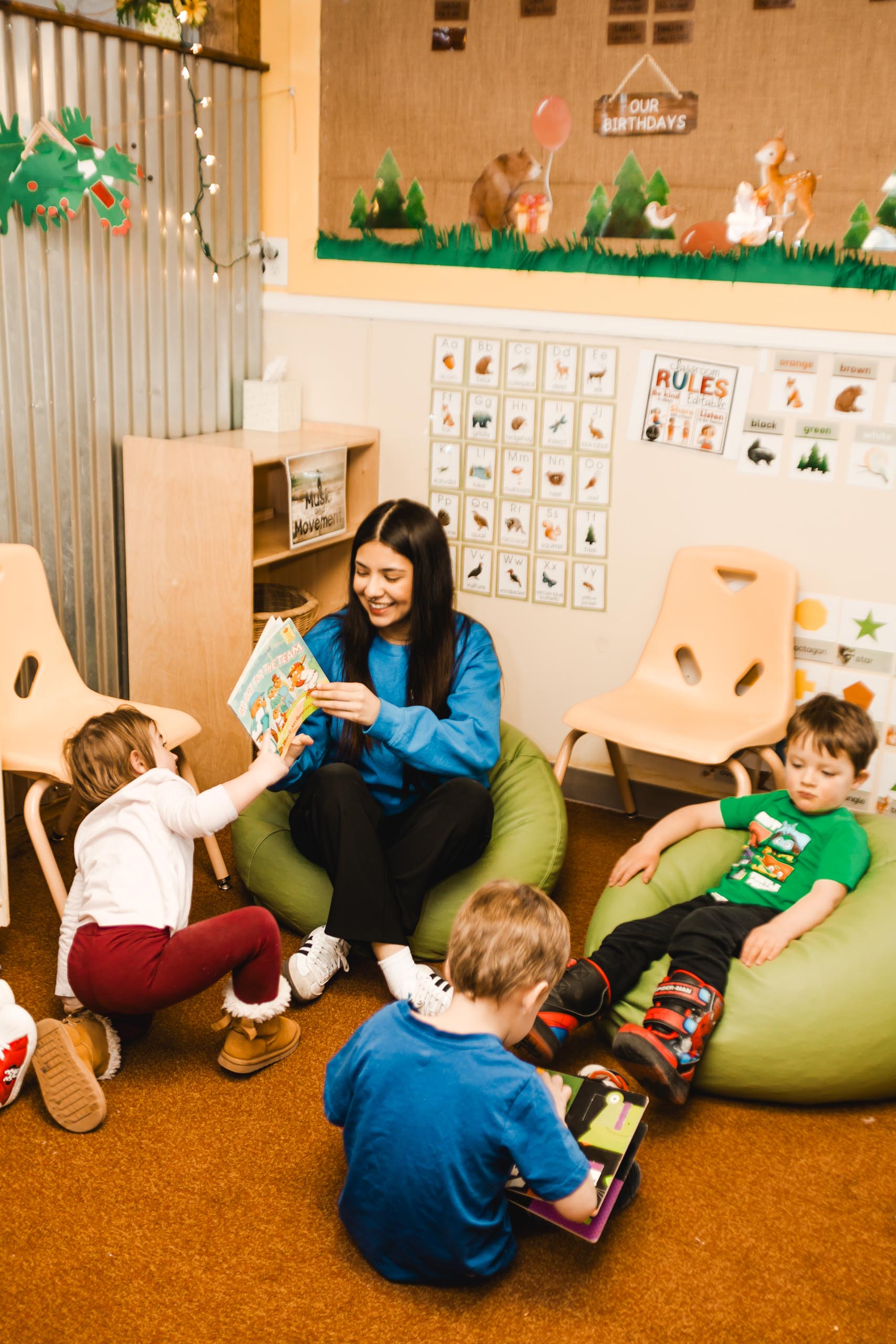 Three children reading with a teacher.