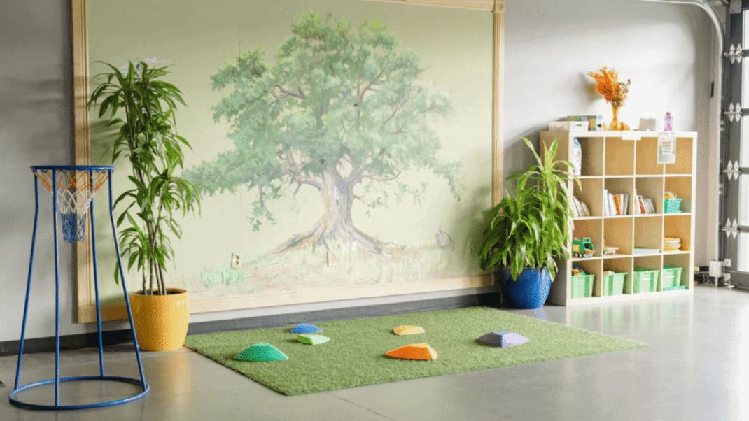 Children's indoor play area with a nature-themed mural and colorful stepping stones.